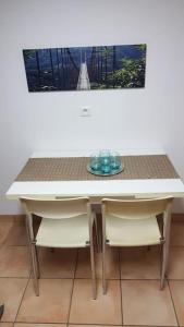 een witte tafel met twee stoelen en een tafel met bij Appartement de 50m2, climatisé avec terrasse et parking in Castelnau-le-Lez