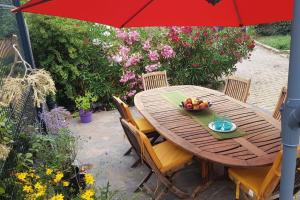 - une table en bois avec un bol de fruits et un parasol dans l'établissement Appartement de 50m2, climatisé avec terrasse et parking, à Castelnau-le-Lez