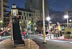 een groep mensen die 's nachts op een speelplaats spelen bij Mirror Apartment Gandia in Gandía