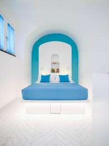 - un lit dans une chambre blanche avec une tête de lit bleue dans l'établissement Casa Andreana, à Amalfi