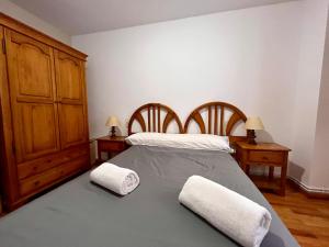 ベナスケにあるBPIRINEOS-Los Tilosのベッドルーム1室(ベッド1台、タオル2枚付)