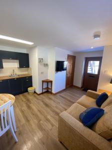 ein Wohnzimmer mit einem Sofa und einer Küche in der Unterkunft Ben View Aberlour Luxury Barn Conversion in Aberlour