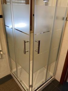 a shower stall with glass doors in a bathroom at Domus B&B in Modugno