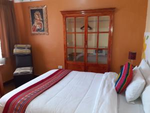 a bedroom with a bed with a wooden cabinet at Reinbo Garden in Cusco