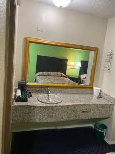 a bathroom with a sink in front of a mirror at Sunrise Inn in Jasper