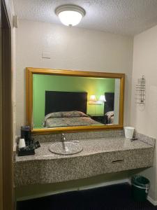 a bathroom with a sink in front of a mirror at Sunrise Inn in Jasper