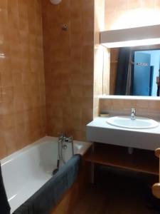 ein Badezimmer mit einer Badewanne und einem Waschbecken in der Unterkunft Superbe appartement en résidence skis aux pieds in Courchevel