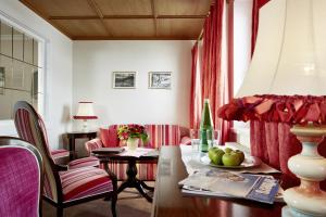 a living room with a table and a chair at Hotel Hirlanda in Zürs am Arlberg