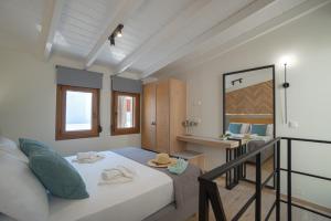 ホラ・スファキオンにあるJacuzzi maisonette in Sfakia center 'New 2023'のベッドとデスクが備わる小さな客室です。