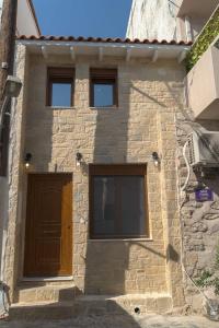 um edifício com três janelas e uma porta castanha em Jacuzzi maisonette in Sfakia center 'New 2023' em Chora Sfakion