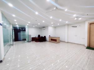 ein großes leeres Zimmer mit einem Schreibtisch und einem Zimmer mit einem Tisch in der Unterkunft BlueNeck Sec 47 Near IKEA GMP Gurugram in Gurgaon