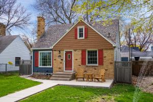 ein kleines Haus mit einer roten Tür und einem Tisch in der Unterkunft Perfect Family Bungalow in Minneapolis