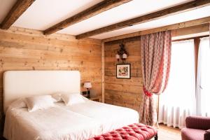 - une chambre avec un lit et un mur en bois dans l'établissement Auberge de La Maison, à Courmayeur