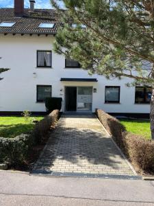 a driveway leading to a white house with a door at Black Forest Apartment in Bad Herrenalb