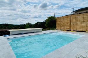 una piscina en un patio trasero con una valla de madera en La maison du Maire en Cayrac