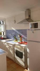 uma cozinha com um fogão e um frigorífico branco em LES VIGNES ET LA PINEDE PRES DE LA PLAGE em Saint-Tropez