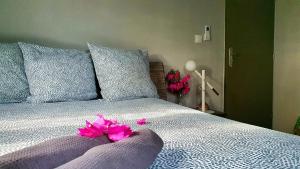 a bedroom with a bed with pink flowers on it at Villa de 2 chambres avec piscine privee jardin clos et wifi a Le Lamentin in Le Lamentin