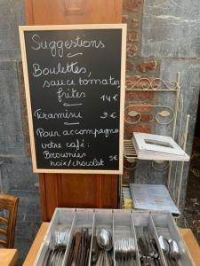 un panneau en carton avec un paquet d'ustensiles sur une table dans l'établissement Hotel Le Limbourg, à Rochefort