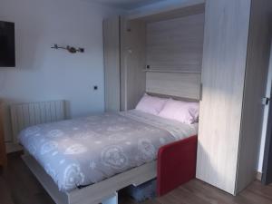 ein kleines Schlafzimmer mit einem Bett in einem Zimmer in der Unterkunft Superbe appartement en résidence skis aux pieds in Courchevel