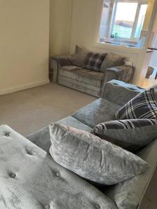 2 bed house near Sefton Park & Lark Lane في ليفربول: غرفة معيشة مع أريكة ووسائد على الأرض