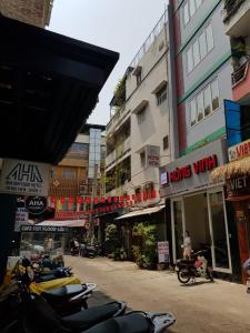 una fila de motocicletas estacionadas frente a los edificios en Hong Vinh Hotel, en Ho Chi Minh