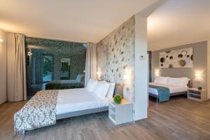 a bedroom with a large white bed and a room with two beds at Villa Costanza- private seasonal warm pool, steam room, sauna-Bellagio Village Residence in Oliveto Lario