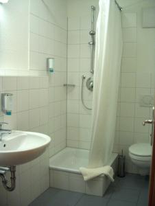 a bathroom with a shower and a tub and a sink at Boardingroom in Filderstadt
