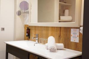 a bathroom with a sink and a mirror and towels at Lloret Vibe Affiliated by FERGUS in Lloret de Mar