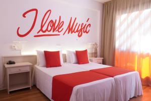 a bedroom with a large bed with a red sign on the wall at Lloret Vibe Affiliated by FERGUS in Lloret de Mar