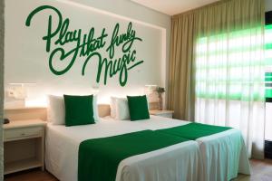 a bedroom with a bed with a sign that says happy those just missing at BPM Lloret Hotel in Lloret de Mar