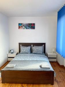 a bedroom with a large bed with blue curtains at Pokoje Slawin in Lublin