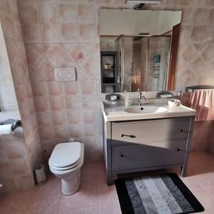 y baño con aseo blanco y lavamanos. en Casa Vacanze Minula - Indipendent Country House, en Carnello