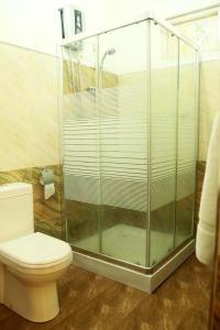 a bathroom with a toilet and a glass shower at Seyru in Kandy