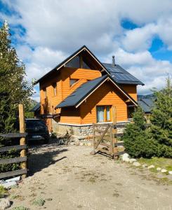 a wooden house with solar panels on the roof at Santa Irene in Lago Meliquina