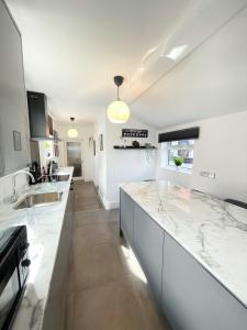 a kitchen with white counters and a counter top at Tettenhall Village Townhouse in Wolverhampton