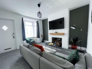 a living room with a couch and a fireplace at Tettenhall Village Townhouse in Wolverhampton