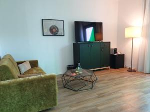 a living room with a couch and a tv and a table at Lloret Vibe Affiliated by FERGUS in Lloret de Mar