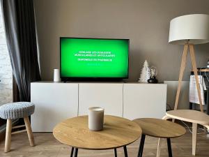 uma sala de estar com uma televisão num armário branco em charmant studio à la Rosière em Montvalezan