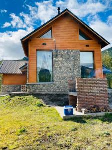 a house on a hill with a blue bucket in front of it at Santa Irene in Lago Meliquina