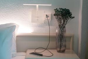 a vase with a plant in it on a table at Lloret Vibe Affiliated by FERGUS in Lloret de Mar