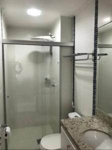 a bathroom with a toilet and a glass shower at Flat 123 - Veredas - 300 metros Hot Park - Vista Piscina in Rio Quente