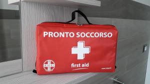 una bolsa roja de primeros auxilios sentada en un estante en Lovely PitStop Fiumicino en Fiumicino
