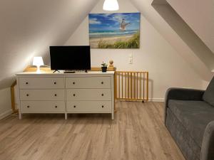 a living room with a dresser with a television on it at Waren Appartements in Waren