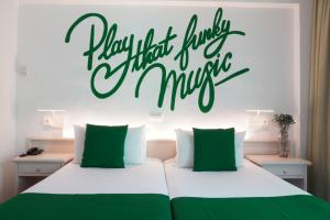 a bedroom with a bed with a sign that reads happy that there is a music at Lloret Vibe Affiliated by FERGUS in Lloret de Mar