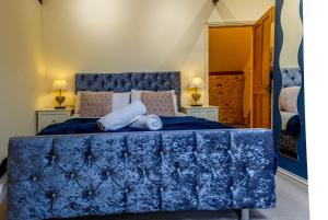 a bedroom with a blue bed with two pillows at Hills Farm Stays in Kilmington