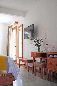 Schlafzimmer mit einem Schreibtisch und einem TV an der Wand in der Unterkunft Casa Cafeólogo in San Cristóbal de las Casas
