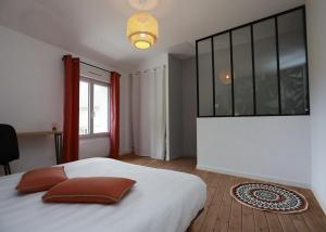 - une chambre avec un grand lit blanc et une fenêtre dans l'établissement Maison Le Lodge- Centre Doué la Fontaine proche zoo, à Doué-la-Fontaine
