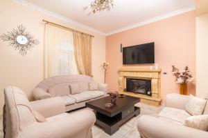 a living room with two couches and a fireplace at Barbara Country House in Zakynthos Town