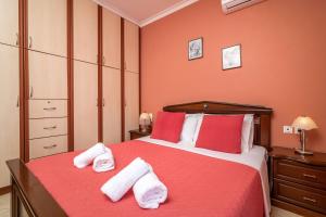 a bedroom with a red bed with towels on it at Barbara Country House in Zakynthos