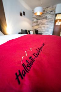 una manta roja con las palabras feliz año nuevo en una cama en Hallstatt Dachstein Inn en Gosau